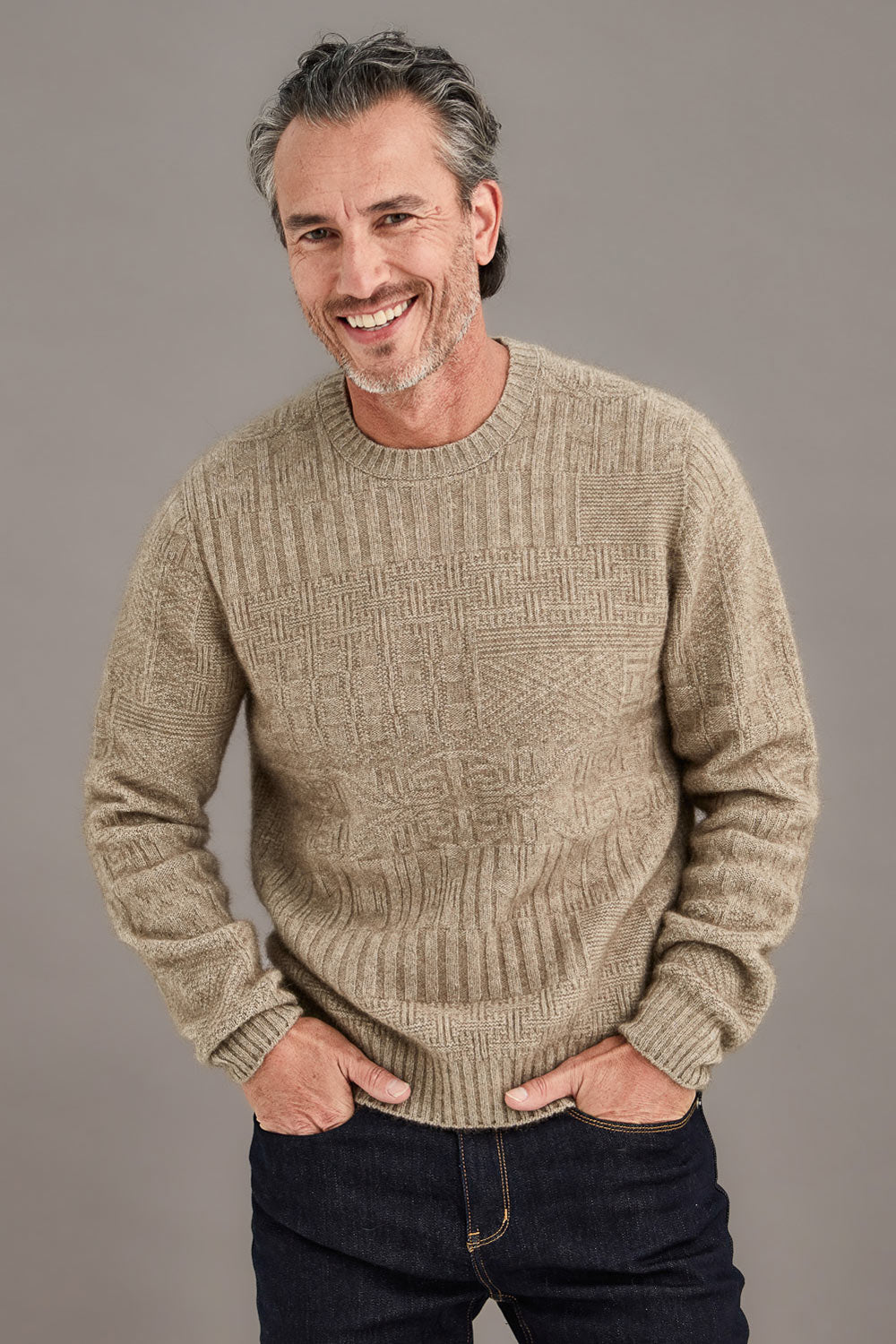 Man wearing a mocha brown detailed sweater against a plain background